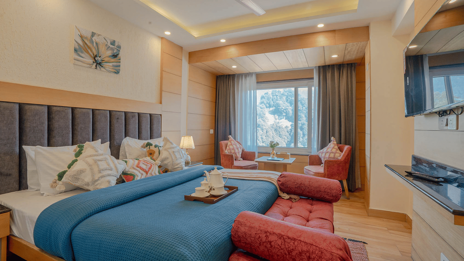 A bedroom with a king size bed, seating area, and window view at Perfectstayz Premium at Mall Road Hotel Super, Mussoorie.