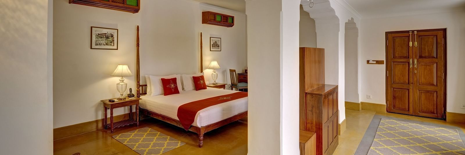 Imperial Suite at Saraca Hotel, Lucknow with a double bed and a large open living space with arched pillars