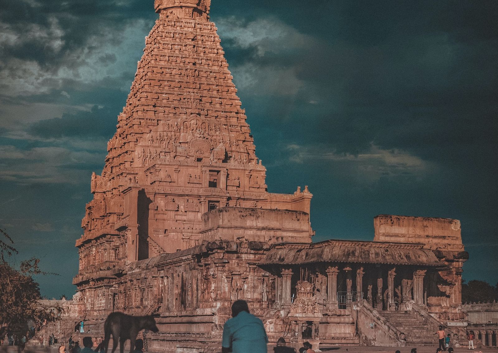 A hindu temple with intricate architecture outside on the roof as seen from a distance
