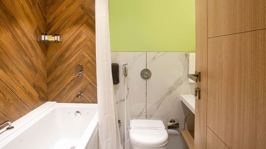 An image of the bathroom at Hotel Bawa Regency, Dadar, featuring a well-furnished marble bathtub.