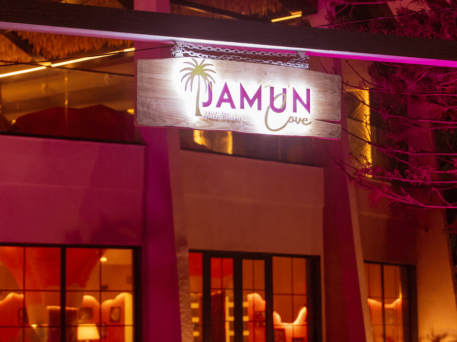 Exterior entrance of Jamun restaurant illuminated with purple lighting at night - Symphony Resorts