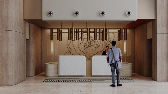 A man standing in a modern, spacious hotel lobby with a minimalist design at The Orchid Hotel, Chandigarh