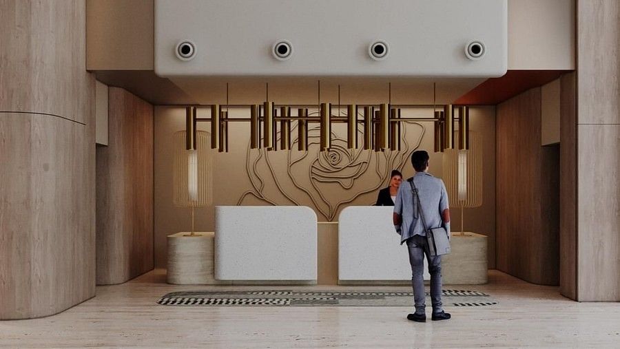 A man standing in a modern, spacious hotel lobby with a minimalist design at The Orchid Hotel, Chandigarh