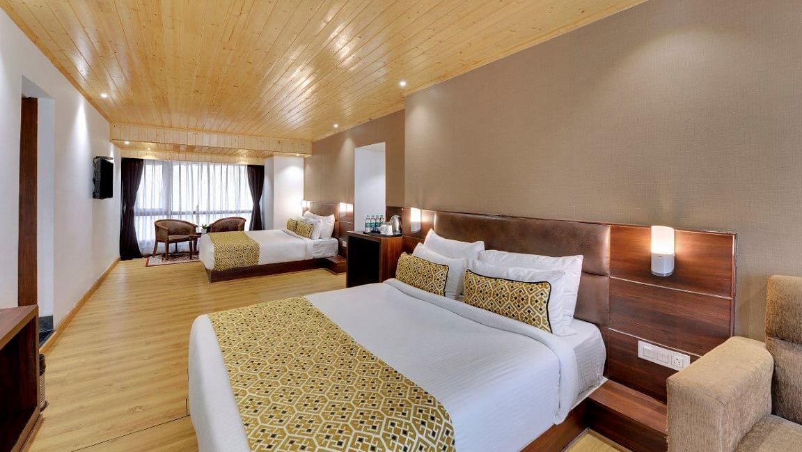 An image of a room with two queen size beds, TV, sofa, lamps and minimal decoration - Sumitel Vista TV Tower