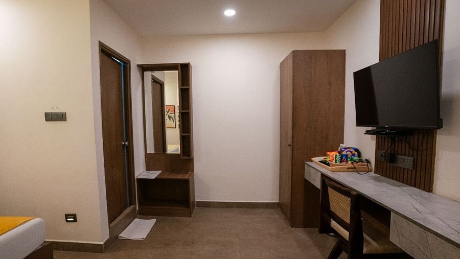 A spacious room with a wide-angle view, showing the work desk, TV, and ample storage cabinets at Hotel Kyzen Smartstays – Smart, Reliable, Kyzen