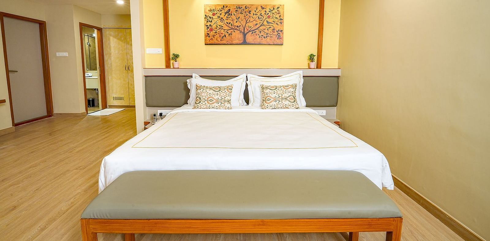 Spacious king-size bedroom at Vasundhara Villa, Ramoji Film City with warm lighting and elegant décor.
