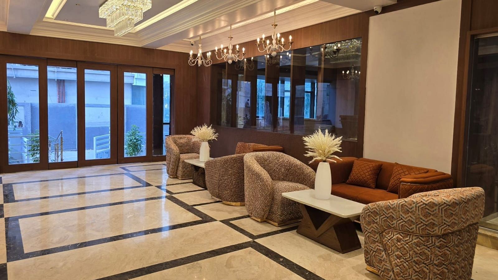 Lobby with stylish seating arrangements and elegant hanging lights from the ceiling at Hotel Mumbai House, Vashi.