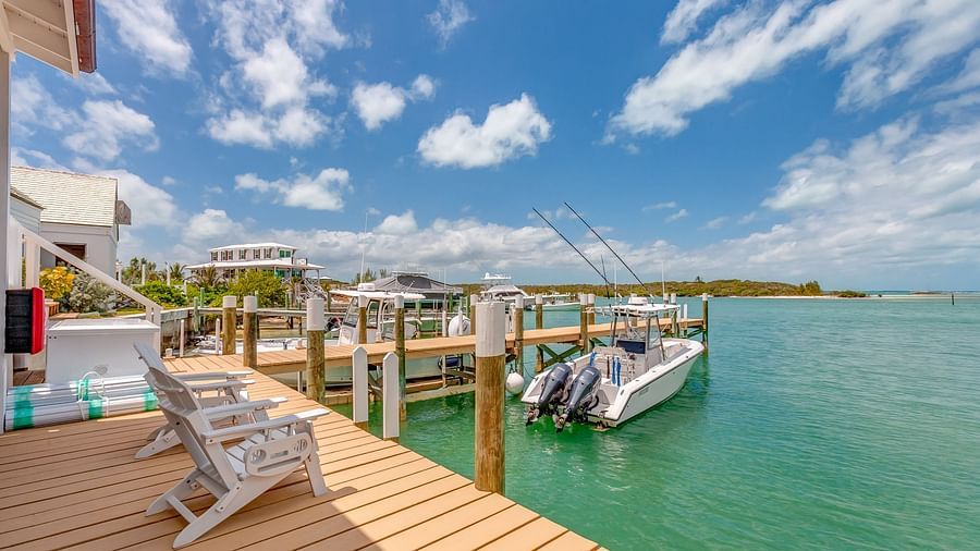 Scenic view of a wooden pier leading to a dock with boats anchored nearby | Abaco Inn
