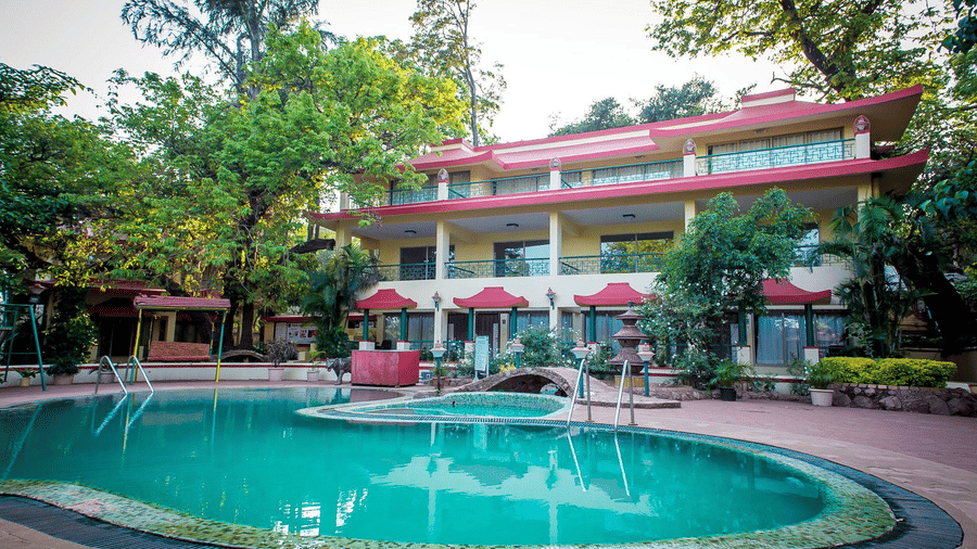 The Adamo The Resort swimming pool with the hotel building behind it during daytime.