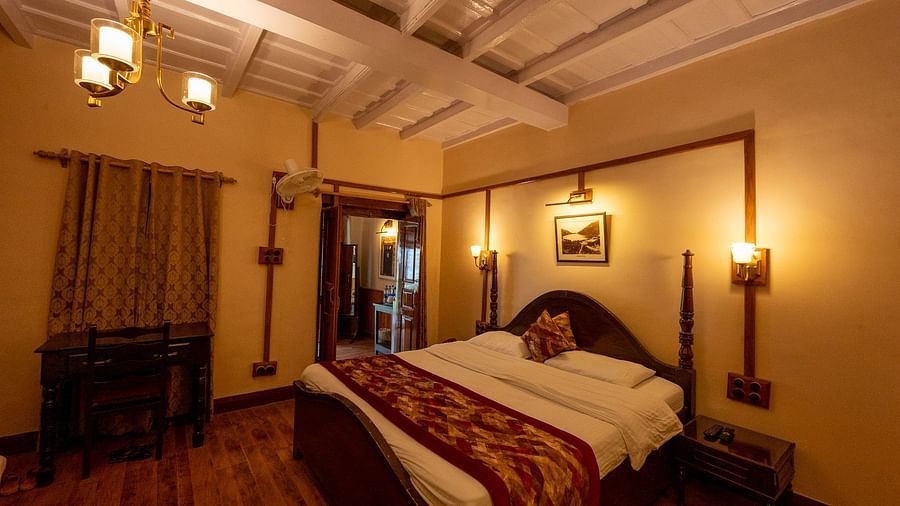Side view of Heritage Room with a cosy bed and stylish interior lighting at Himalaya Hotel, Nainital