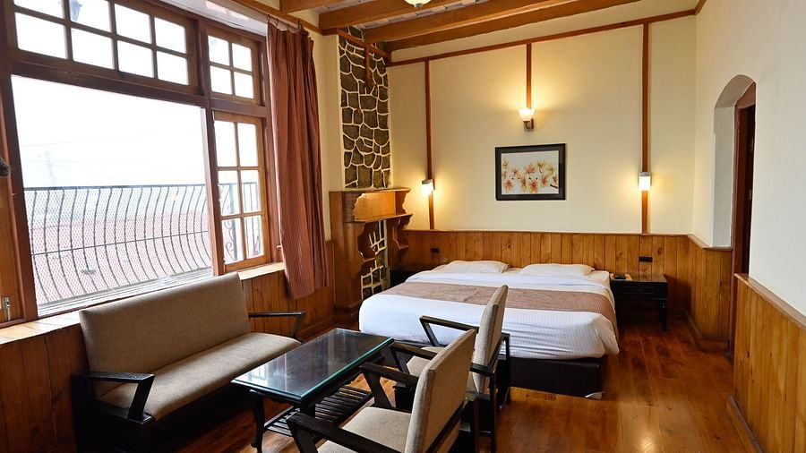Front view of a cosy bed and sofa in Heritage Family Suite at Himalaya Hotel, Nainital