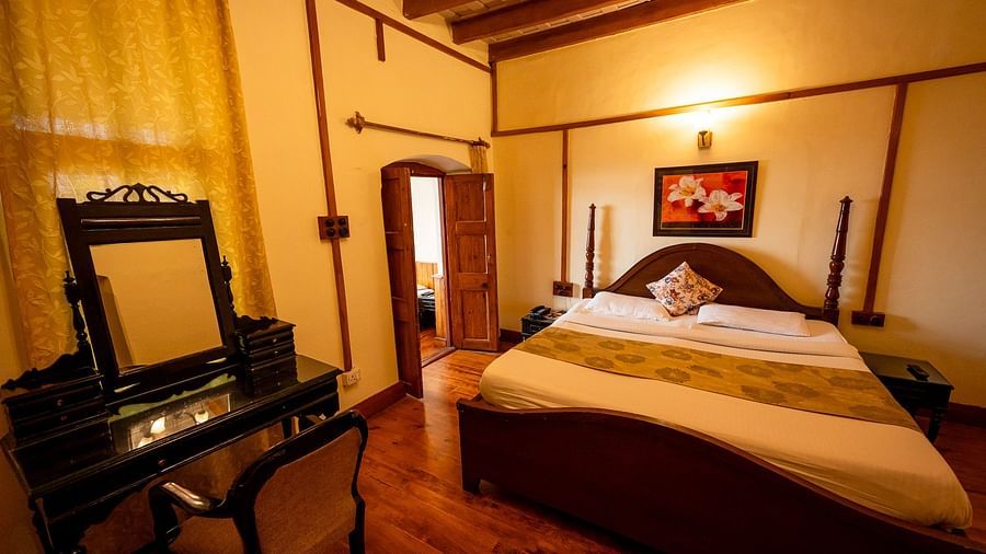 Front view of a cosy bed and a open door to balcony at Himalaya Hotel, Nainital