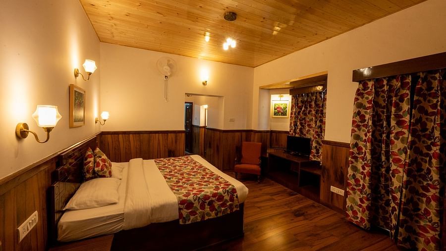 Side view of the family room with a cosy bed and stylish interior lighting at The Pavilion, Nainital