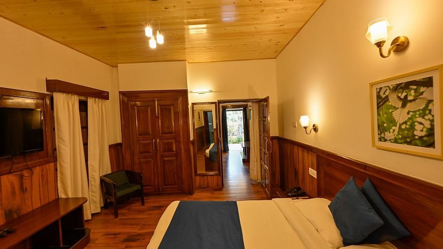 Side view of the family room with a cosy bed and a TV mounted on the wall at The Pavilion, Nainital