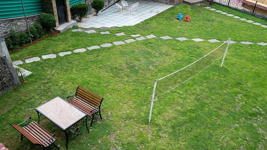 Aerial view of the badminton court with a chair, table, and net at The Pavilion, Nainital