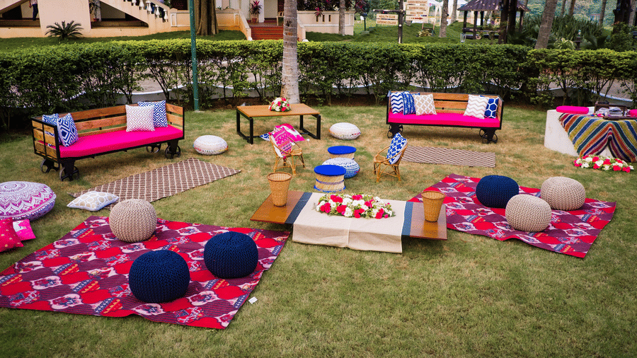 Casual outdoor seating area on a lawn, featuring colourful cushions, low tables, and a relaxed bohemian theme - Black Thunder, Coimbatore