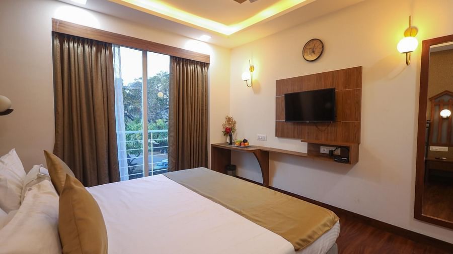 Deluxe room with bed and television at Vagator Downtown, Goa 