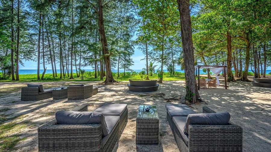 well arranged dining area amidst tall green trees and a clear blue sky - Maikhao Dream Villa Resort & Spa, Phuket