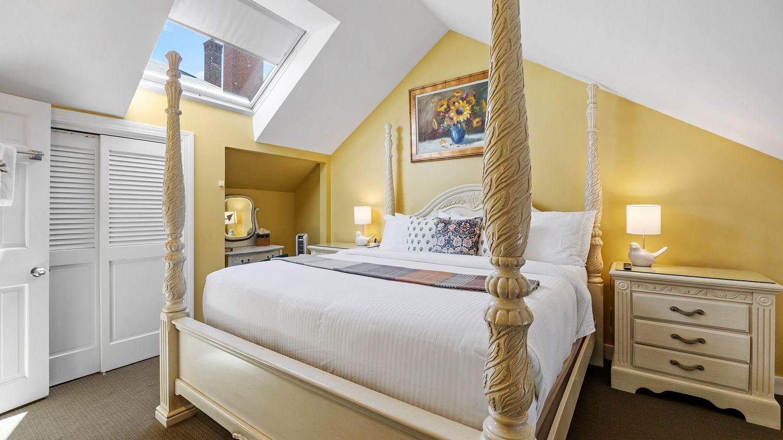 A room featuring a four-poster bed, skylight, and yellow walls at Hartstone Inn