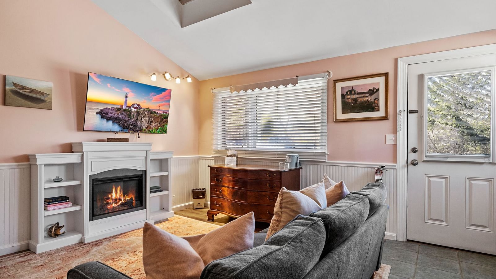 Living room with fireplace, flat screen TV, and large window at Hartstone Inn