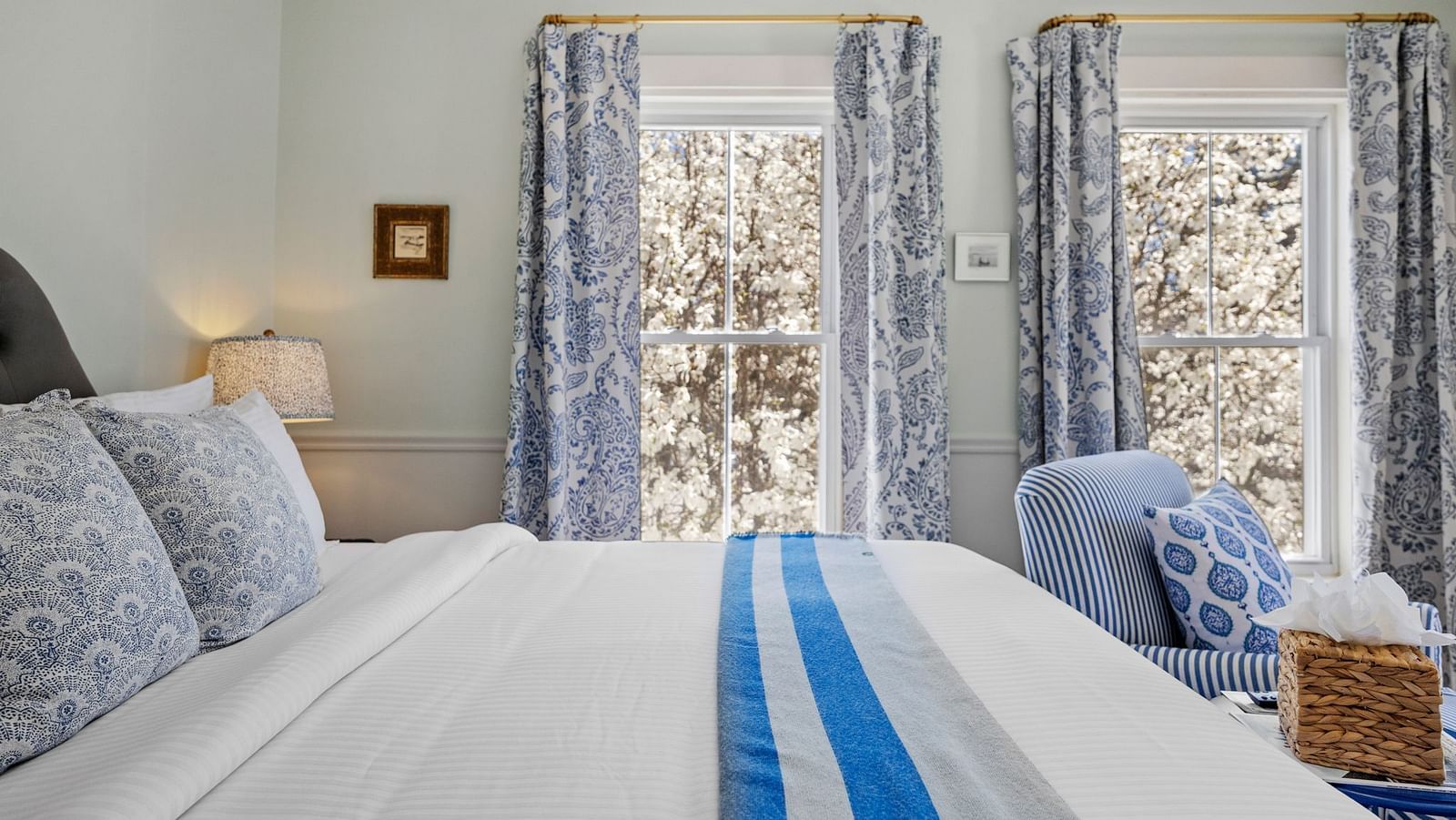 Bed with blue-striped runner and patterned curtains at Hartstone Inn