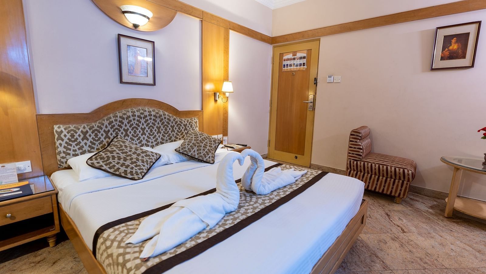 a double bed with a cushioned headboard inside one of the rooms - Hotel Pai Comforts, JP Nagar