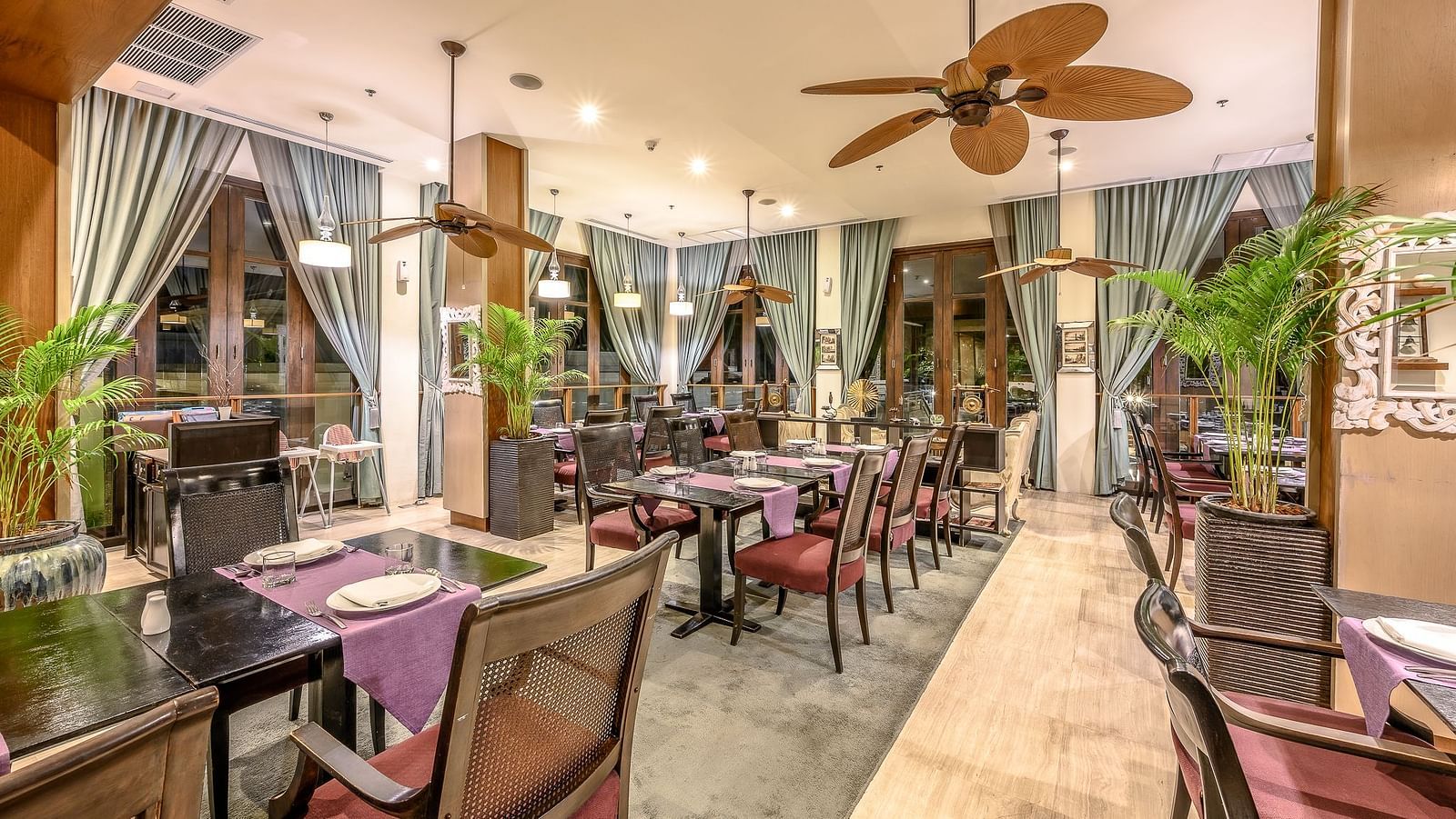 A cosy indoor dining area with well arranged seating arrangements, featured with well designed ceiling fans and curtains - Maikhao Dream Villa Resort & Spa, Phuket