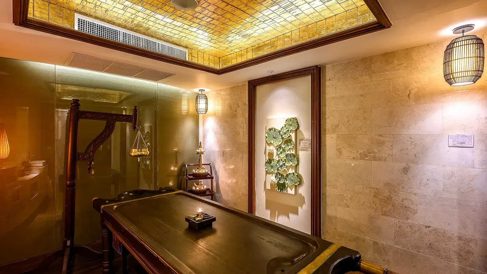 A dimly lit spa treatment room with a massage table and Thai-inspired decor. - Maikhao Dream Villa Resort & Spa, Phuket