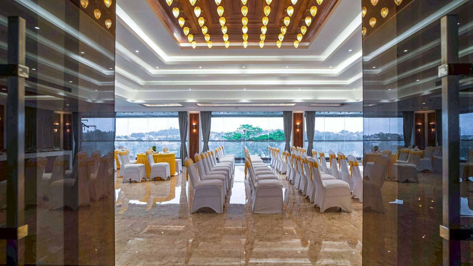 A beautifully decorated event space at Mansha Palace, likely set for a wedding, overlooks a scenic waterscape.