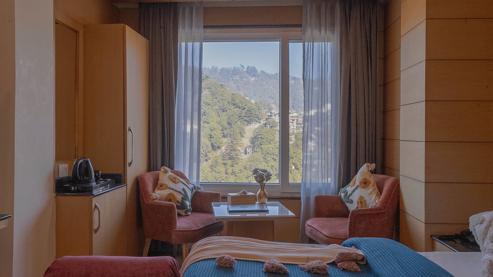 A seating area with chairs, table, and window view at Perfectstayz Premium at Mall Road Hotel Super, Mussoorie.