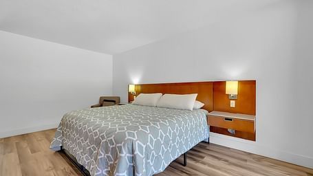 A view of a room at Amador Hotel with a double bed and side lamps.