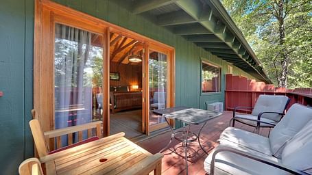 A view of the outdoor patio area o a cabin with sofa seating and a coffee table - Narrow Gauge Inn - A Serenite Hotel Near Fish Camp.