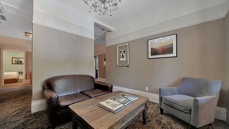 Living room area of a suite at The Groveland Hotel with sofa seating and a coffee table.