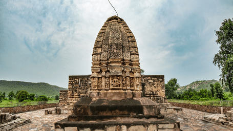 An overview of Neelkanth temple with a mountain backdrop and a clear sky.