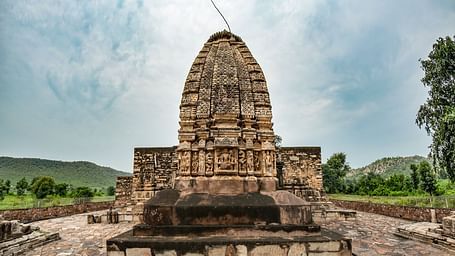 An image of Neelkanth temple with a mountain backdrop and a clear sky