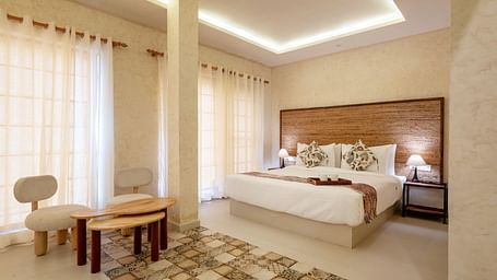 A room with a bed and a seating area in front at Valley by Grassfield.