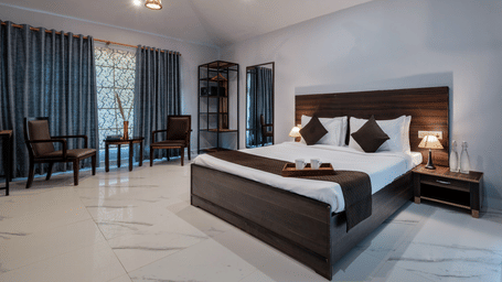 French Premium bedroom with seating for 2 and a table at Valley by Grassfield, a resort in Jaipur.