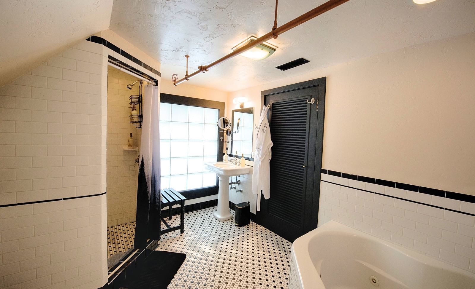 a bathroom featuring a jetted tub along with a huge window in the far corner - Historic Tapoco Lodge
