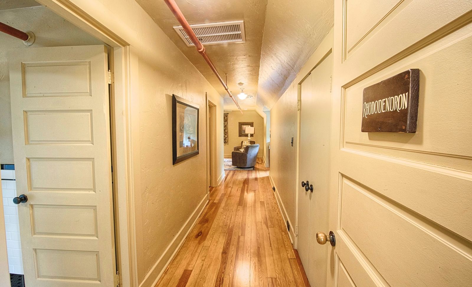 the corridor with wooden flooring and white colored doors leading to various rhododendron suites - Historic Tapoco Lodge