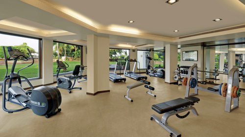 An overview of a vast spacious area with ample natural lighting having numerous gym equipments at Pulse Gym inside Kenilworth Resort & Spa, Goa.
