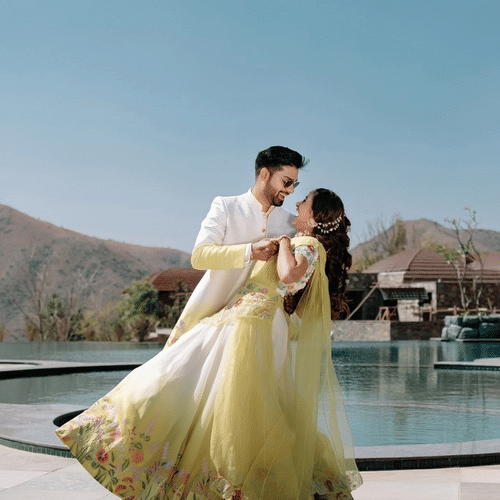 a couple in front of the swimming pool doing a dance pose