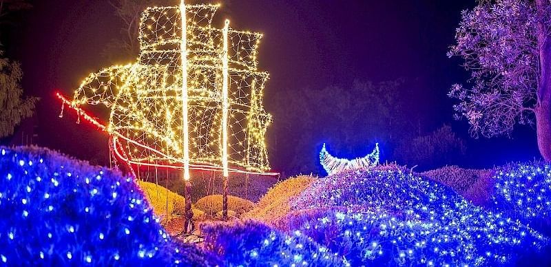 A glowing ship-shaped light installation in a vibrant nighttime display.