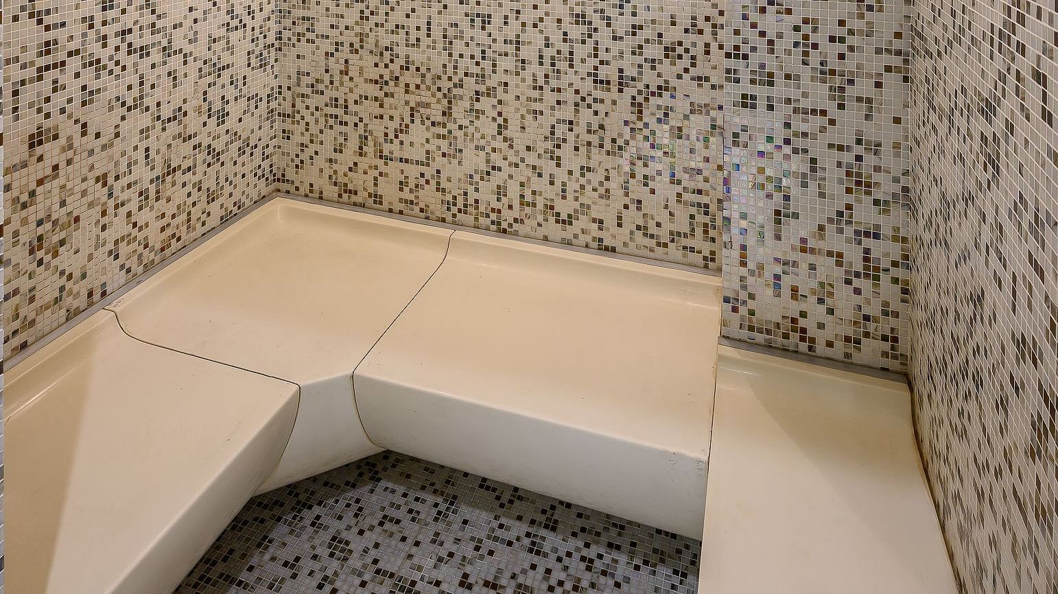 image of a tiled room with white coloured seats at maikhao dream spa