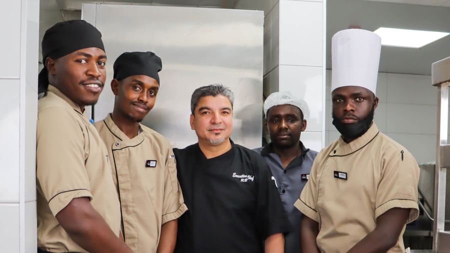 Group of restaurant staff standing with a food trolley in a kitchen at Asiatic Lounge.