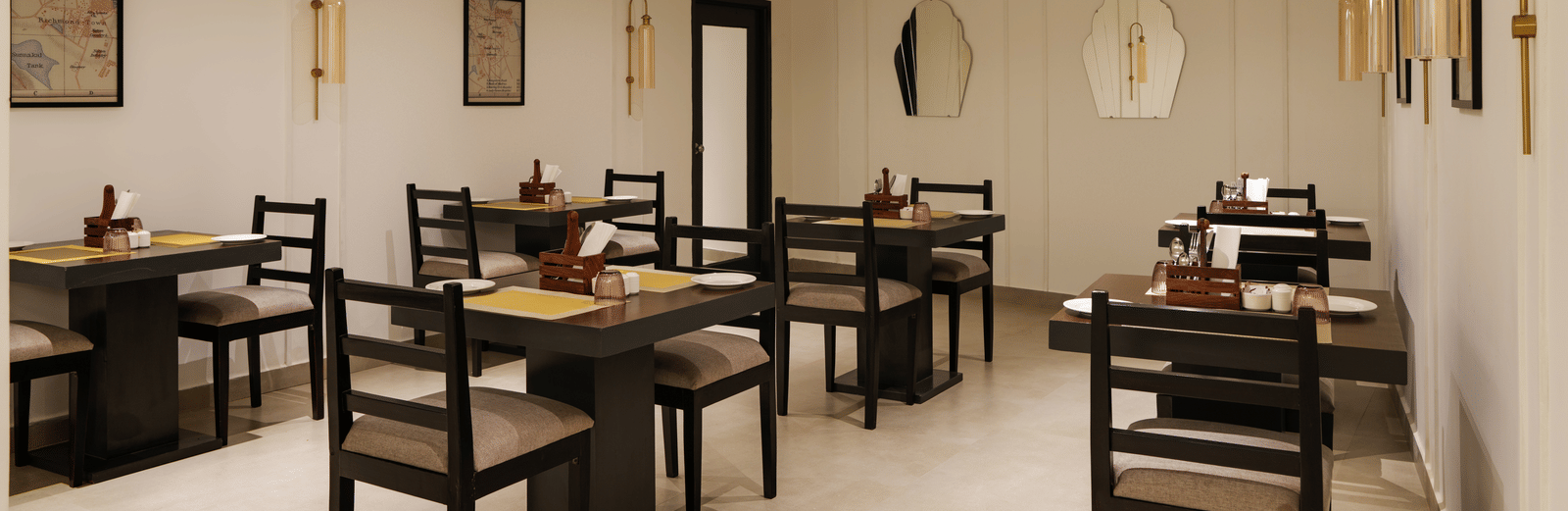 Restaurant at Shilton Suites, Bengaluru, with tables, chairs, and elegant interior furnishings.