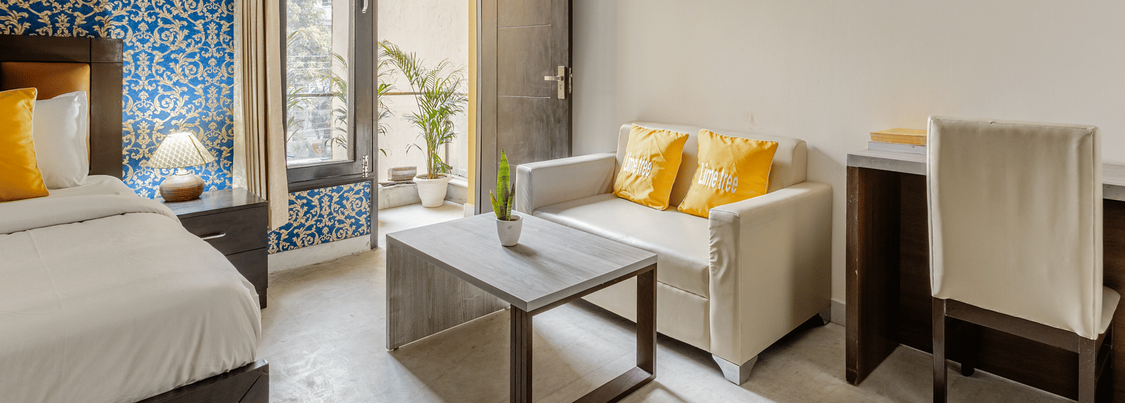 Room view with sofa and entry to balcony at Lime Tree