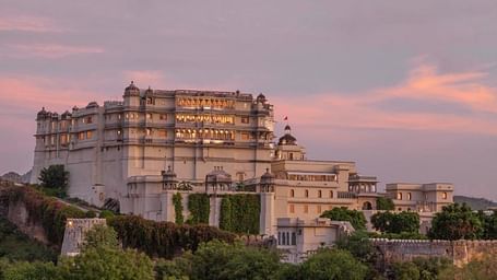A image of Devigarh Doongri covered in mountains with a backdrop of purple sunset