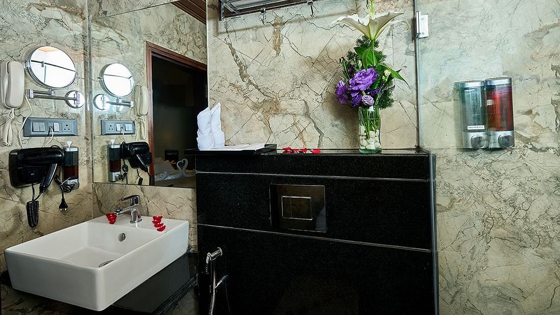 A image of a bathroom with a sink, mirror and toiletries placed in a meticulous manner