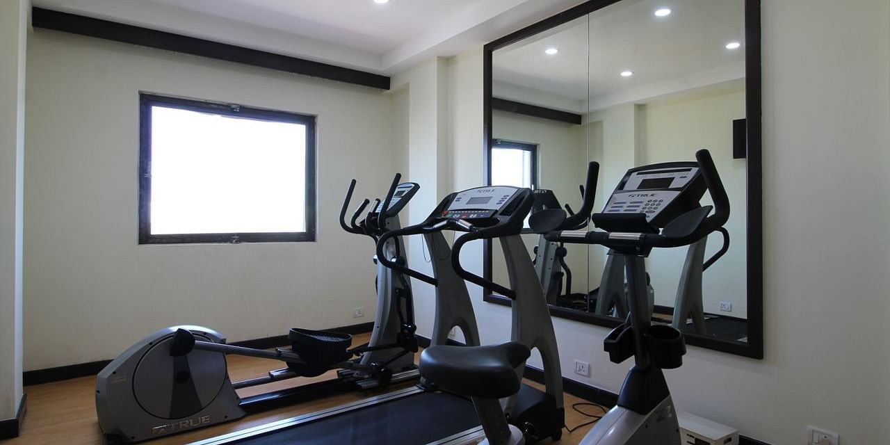 Gym with equipements placed before a mirror along with bright lighting