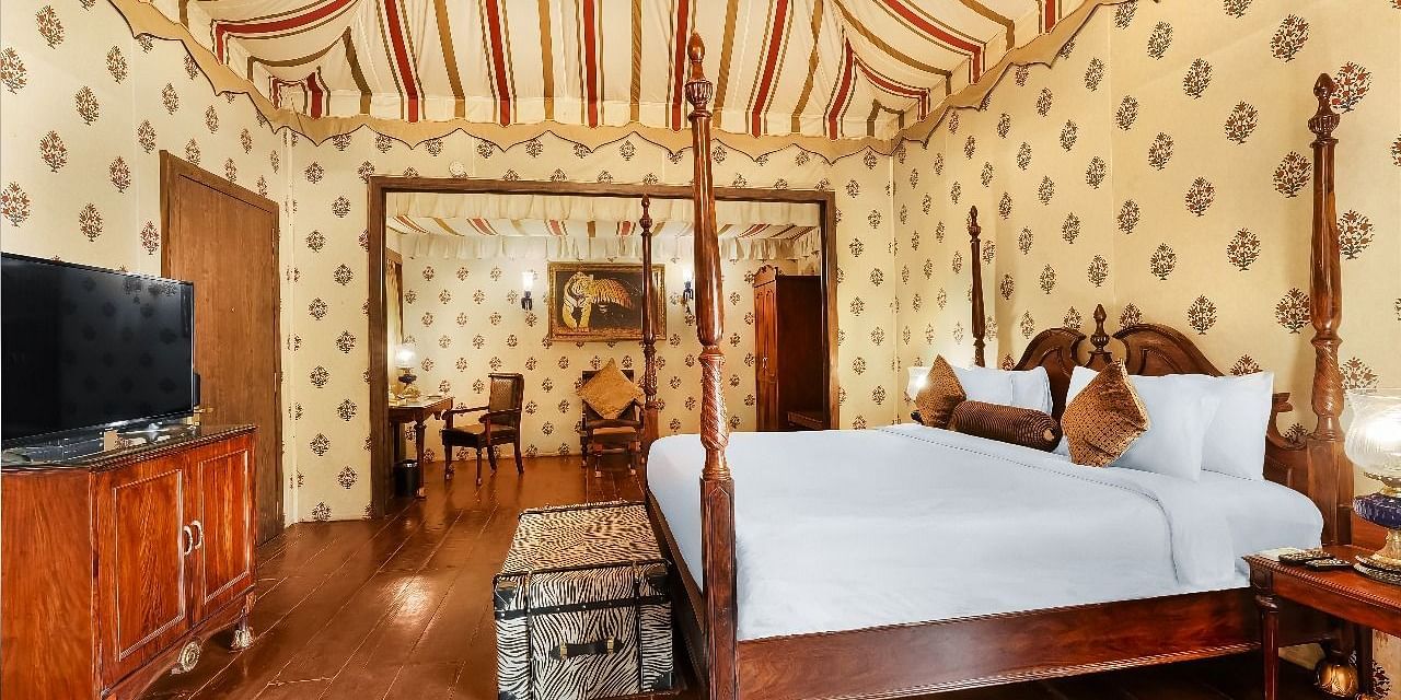 Grand tented suite with canopy ceiling, wooden decor and luxury bed at Rajasthali Resort Jaipur